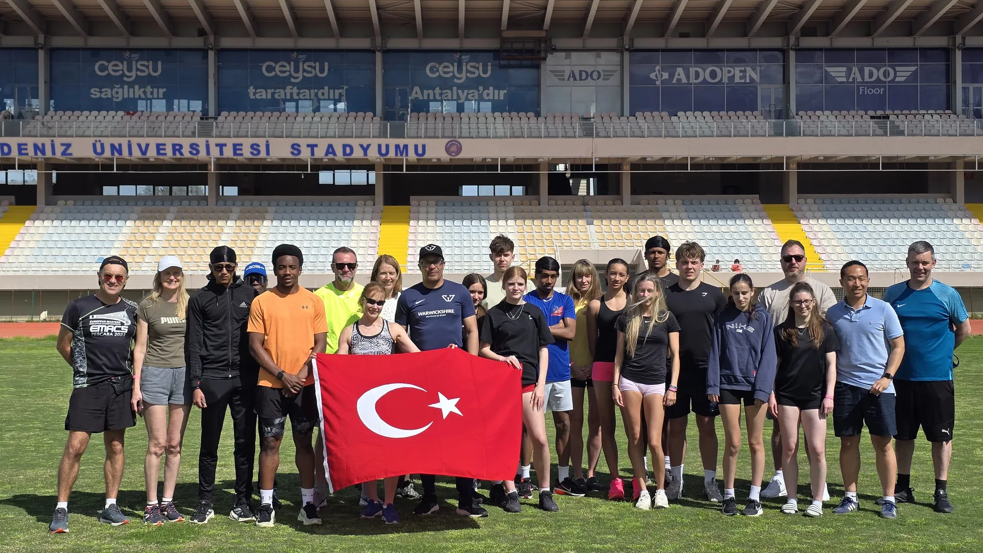 International squad holding the Turkish flag on the stadium infield