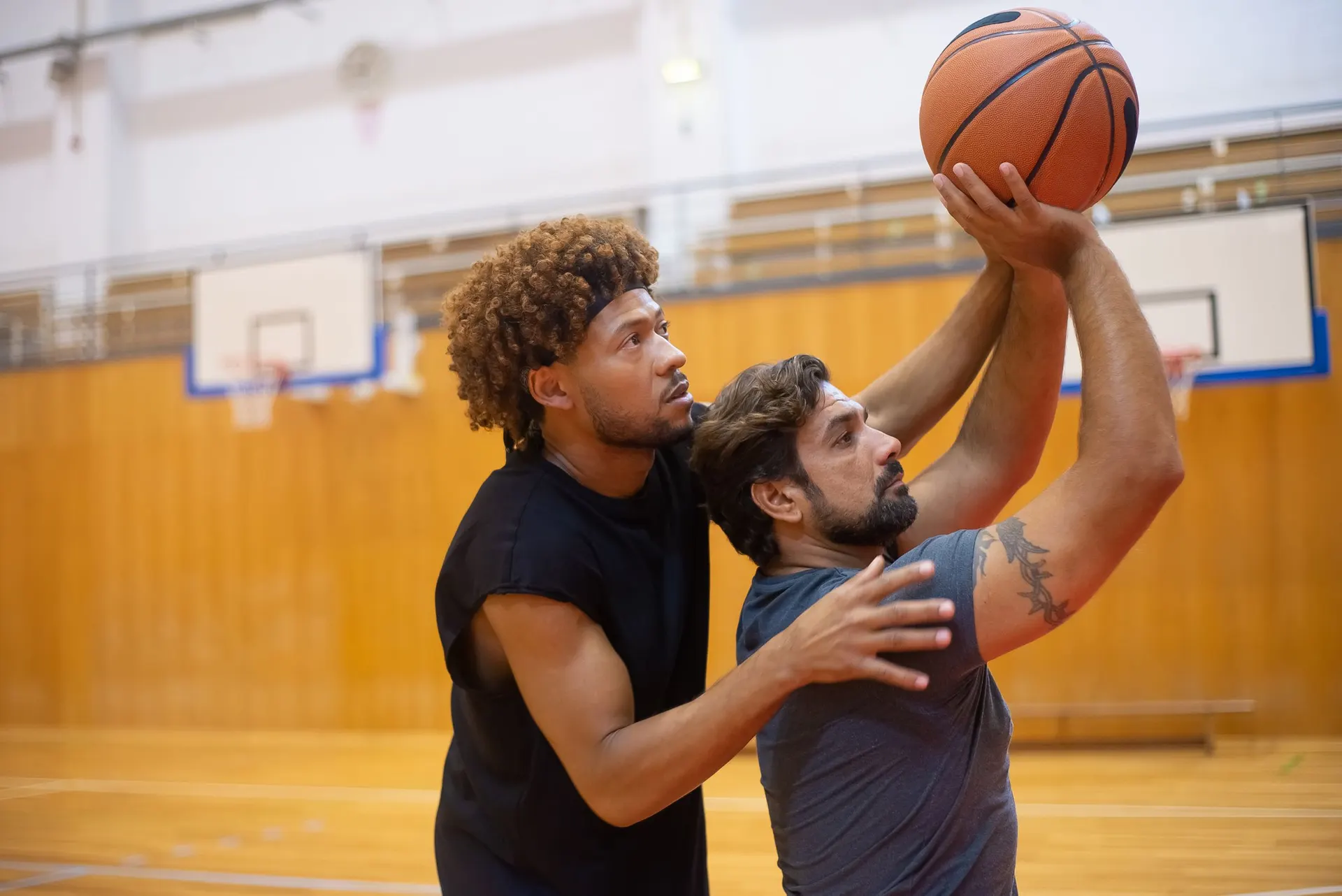 Basketball player rising for a shot as a defender closes out