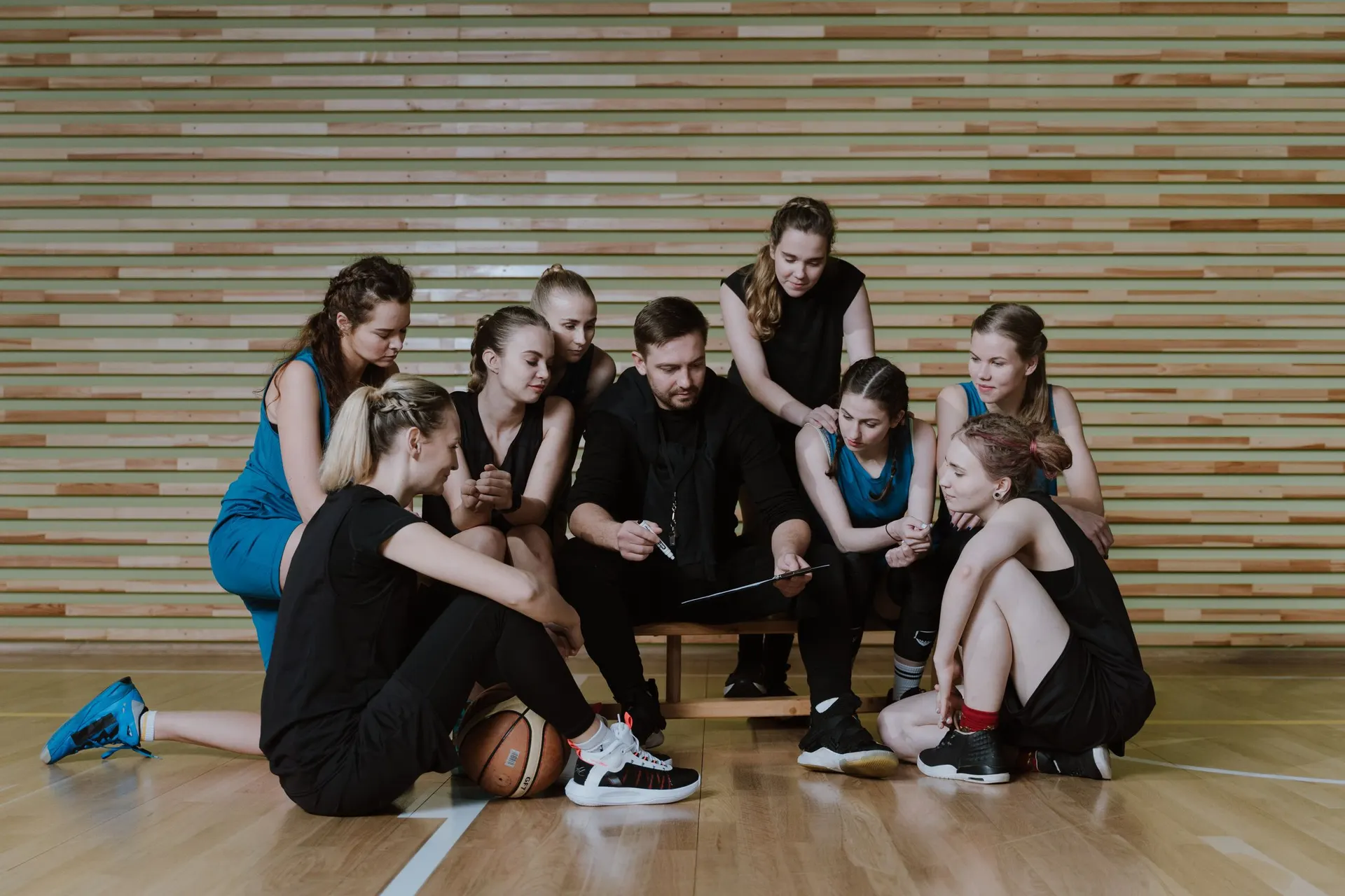 Coach going through tactics with a basketball team on the bench
